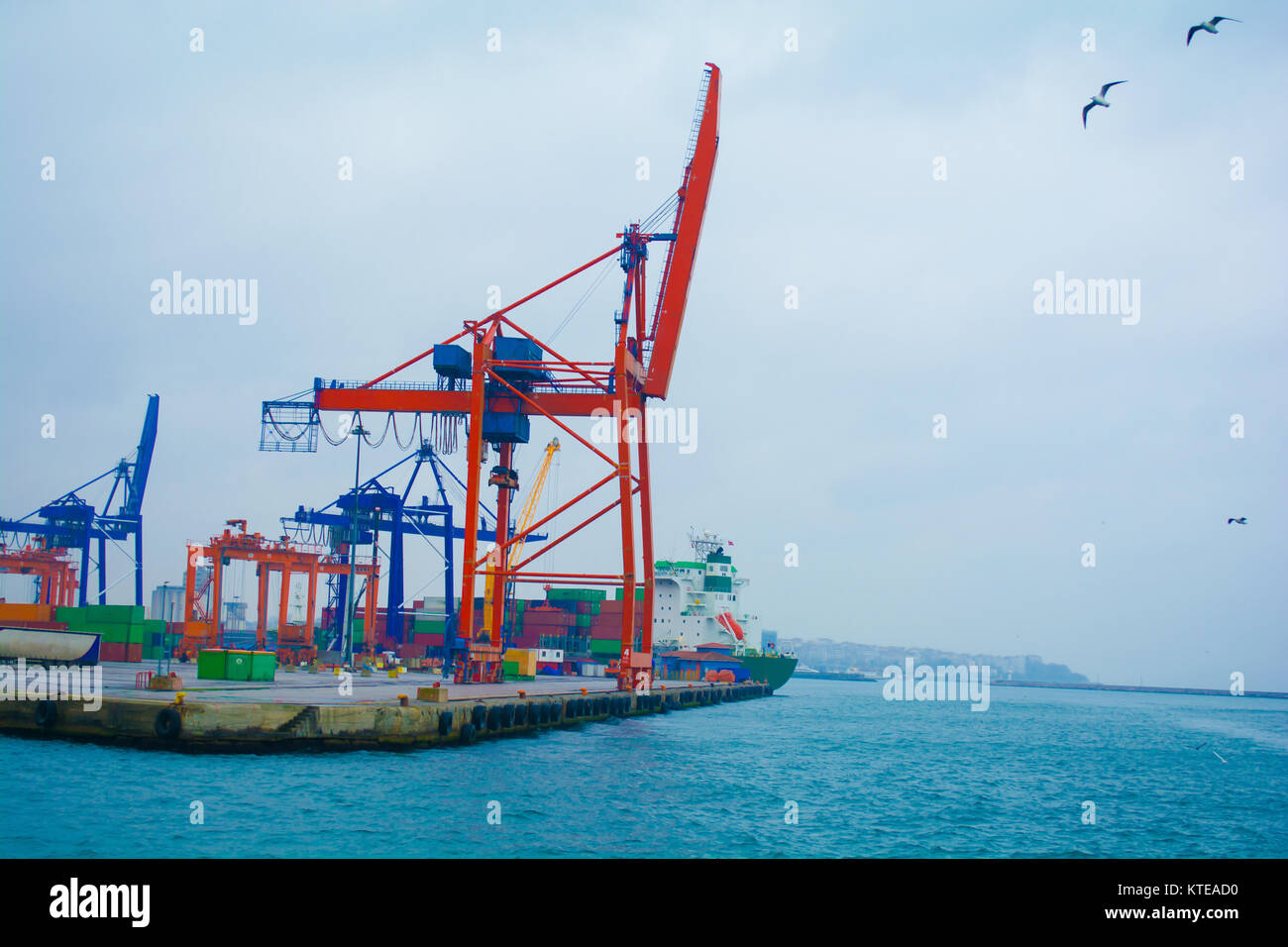 mechanical cranes lifting freight at pier in istanbul turkey Stock Photo