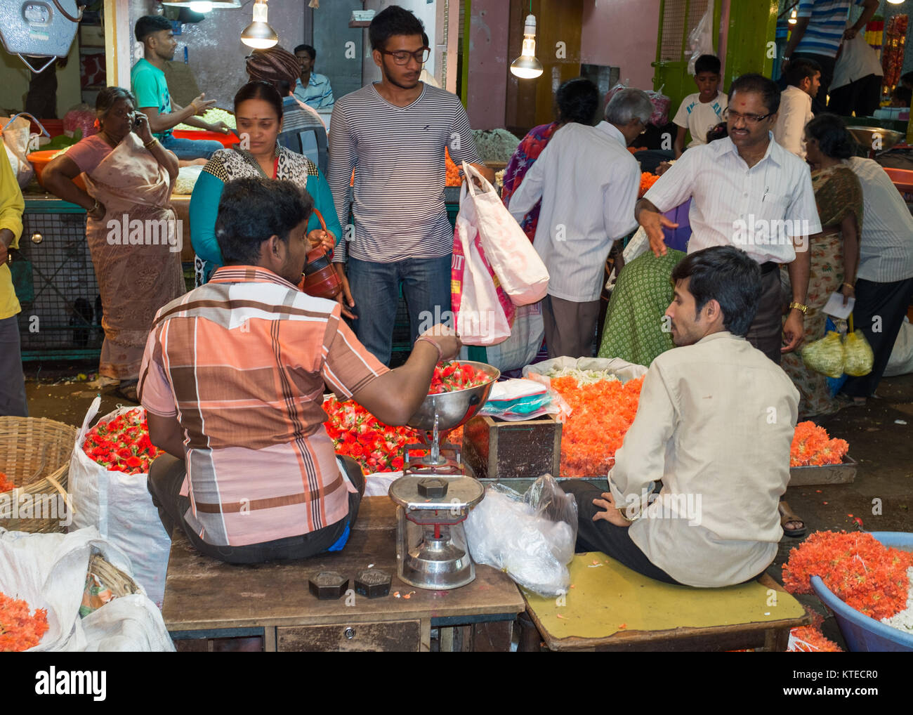 Market vendor weighing flowers while selling to customer at Sri Krishna Rajendra Market in Bangalore, Bengaluru, Karnataka, India, Asia. Stock Photo