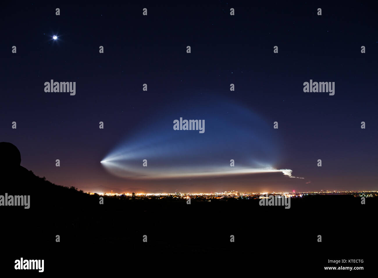 SpaceX Falcon 9 rocket launch from Vandenberg Air Force Base viewed over downtown Phoenix, Arizona Stock Photo