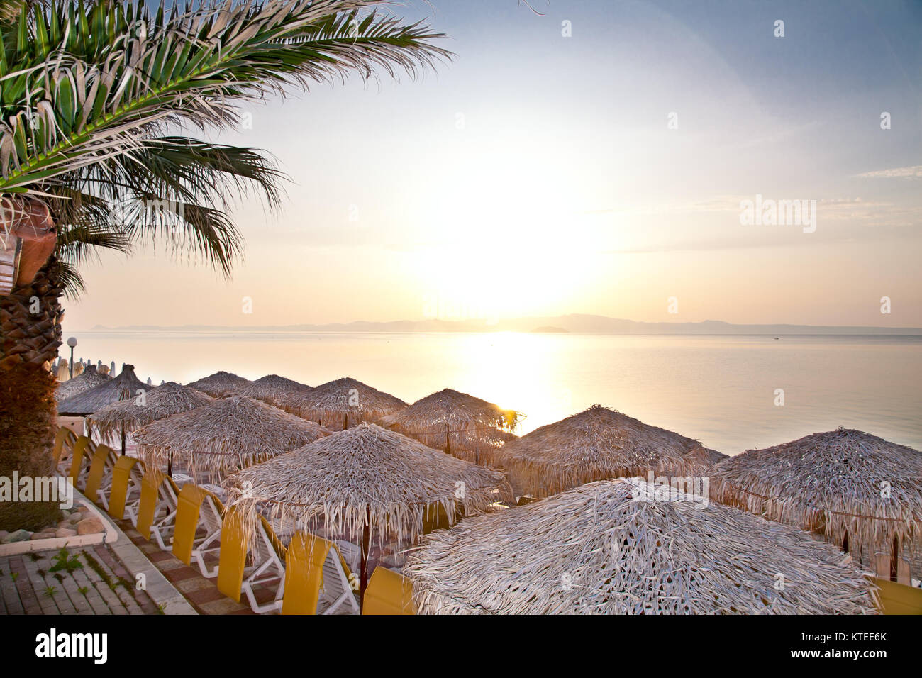 Beach umbrella on the beach at sunset, Hanioti, Greece. Stock Photo