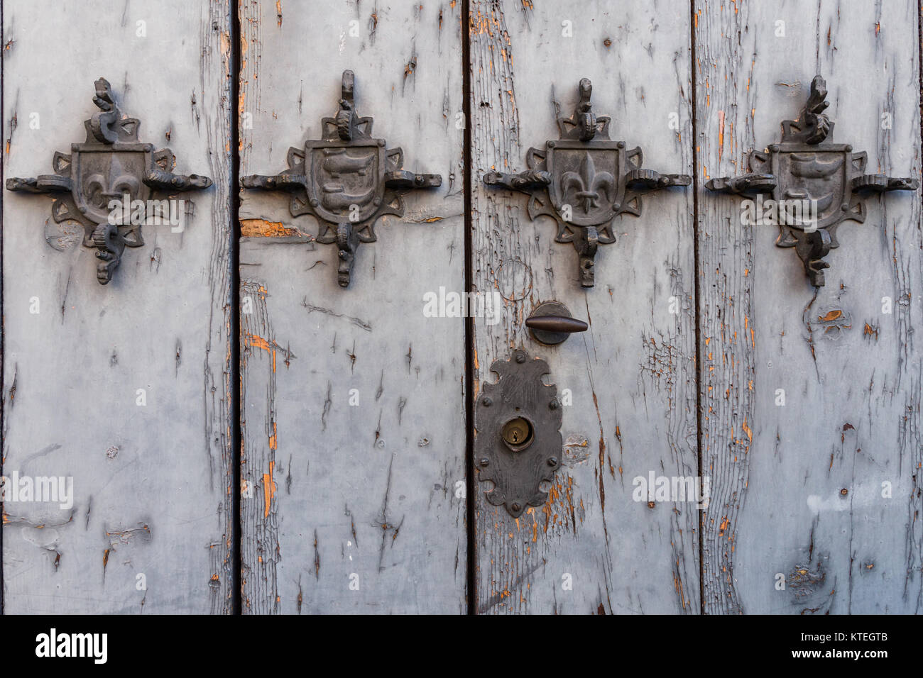 metal embellishments on a painted weathered wood door Stock Photo Alamy