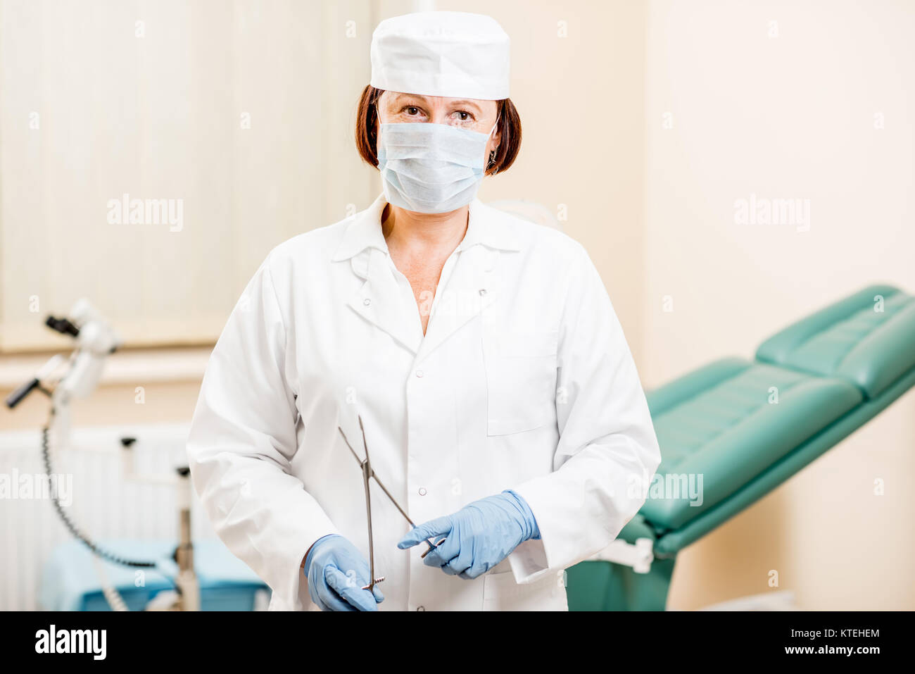 Portrait of a senior woman gynecologist in medical gown, hat and gloves