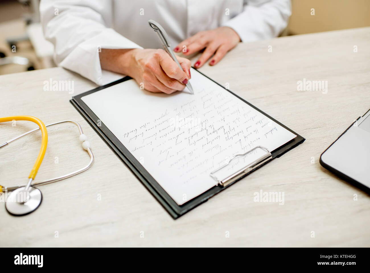 Senior doctor writing recipe on the table with documents. Close-up view ...