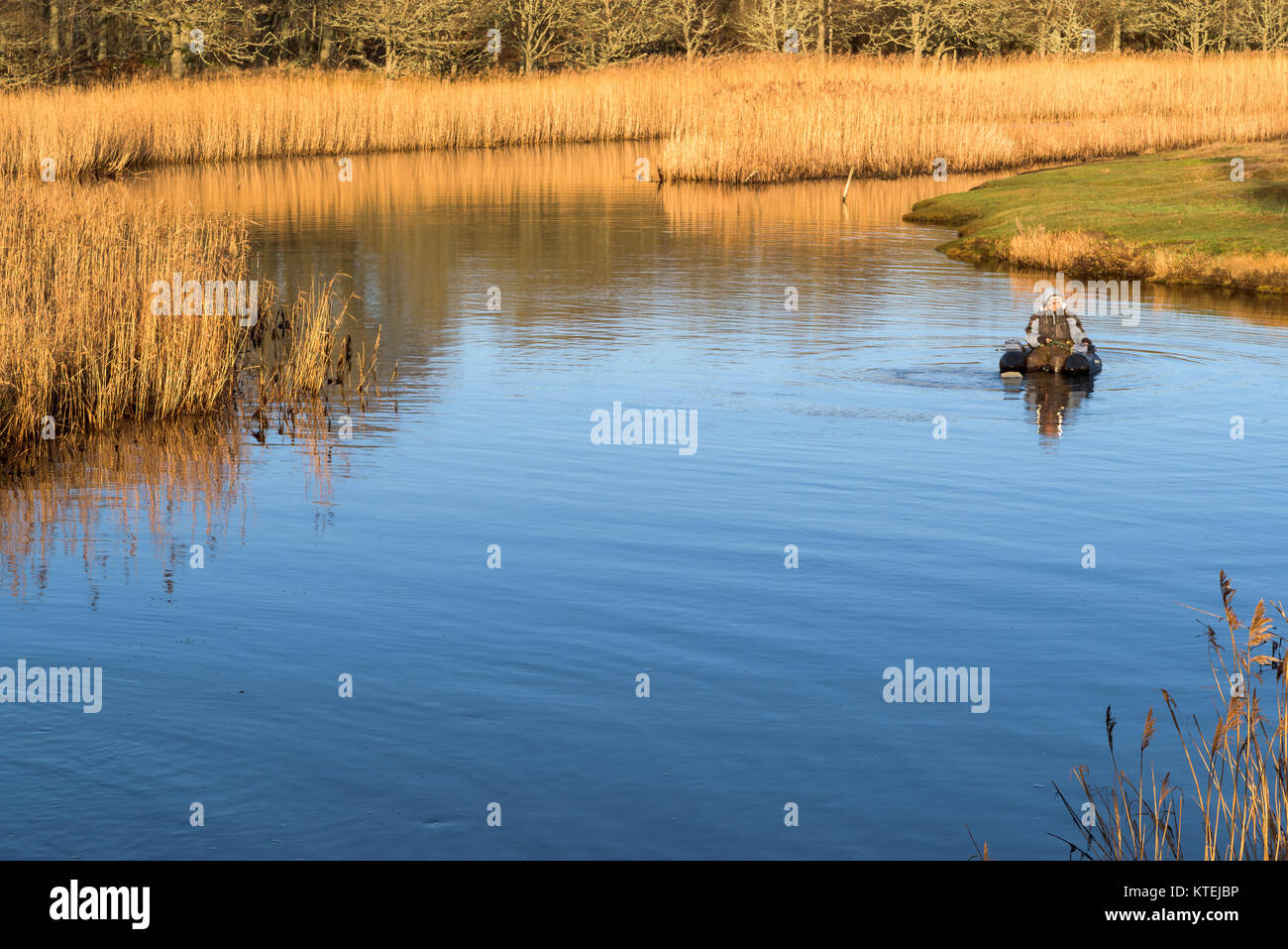 Millegarne, Sweden - December 17, 2017: Documentary of everyday life and environment. Person using an inflatable chair while fly-fishing after pike am Stock Photo