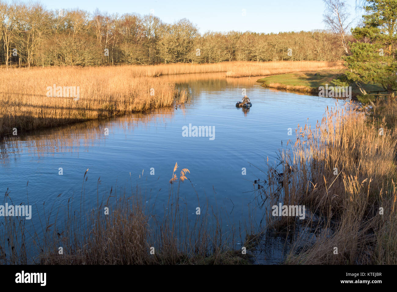 Millegarne, Sweden - December 17, 2017: Documentary of everyday life and environment. Person using an inflatable chair while fly-fishing after pike am Stock Photo