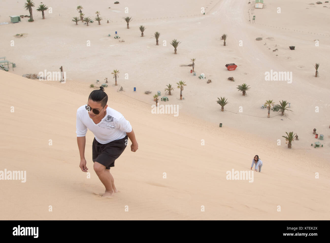 A young Filipino climbs Dune 7, the highest sand dune in the world, in