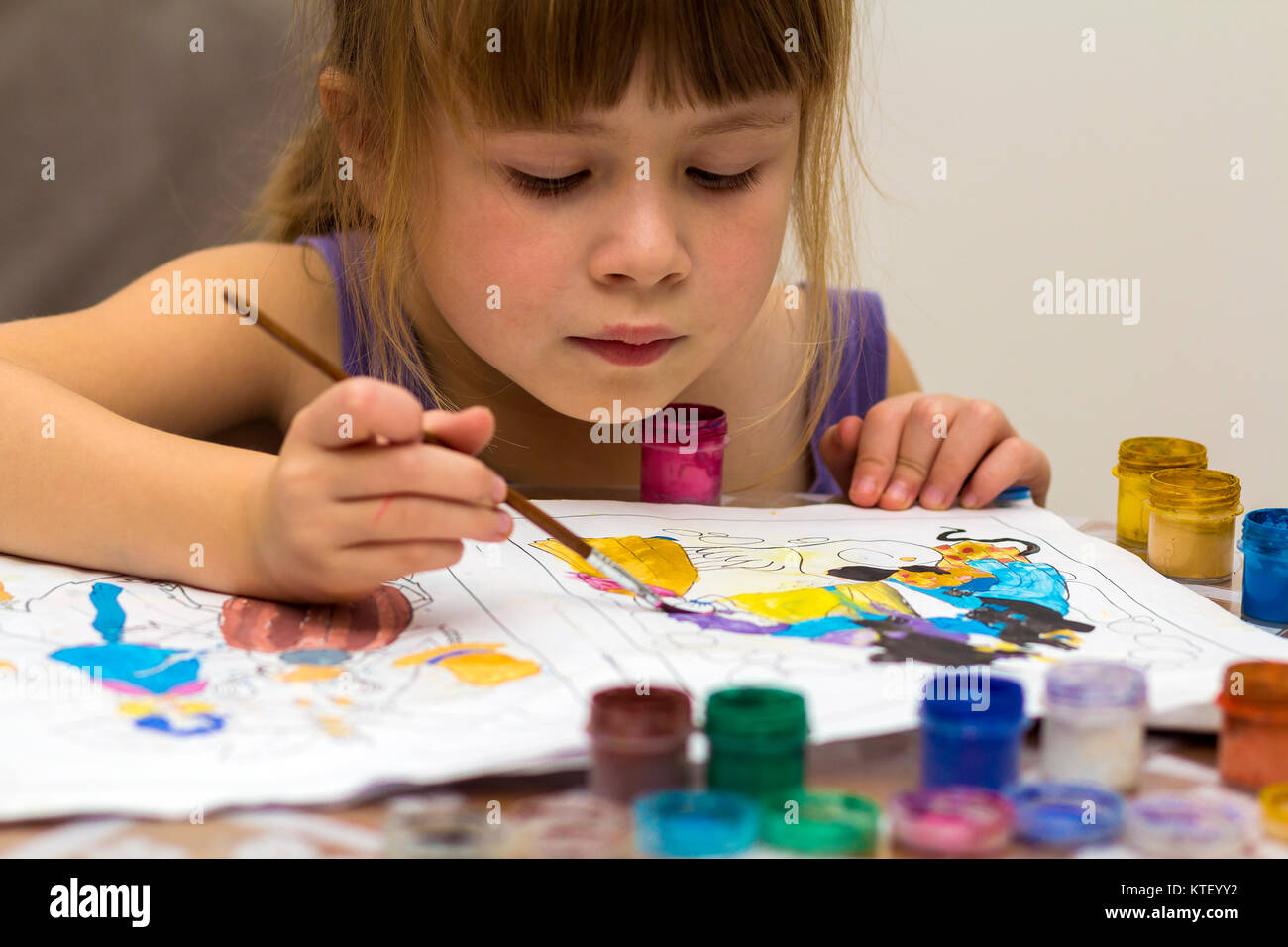 Cute little girl painting with brush and colourful paints Stock Photo ...