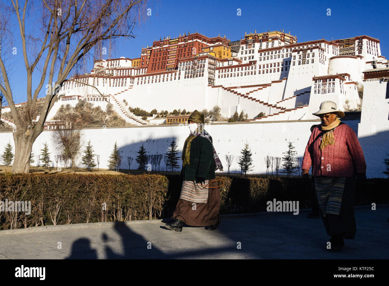 Tibetan pilgrims walking the Kora around the Potala Palace. Lhasa, Tibet Stock Photo