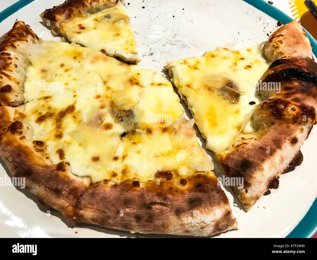 Pizza 8 cheeses, cut slices on plate. Studio Photo Stock Photo - Alamy