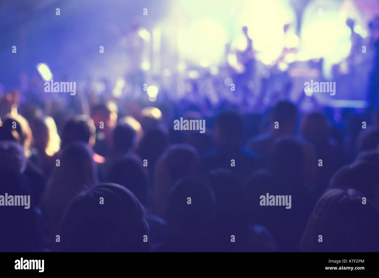 A crowd of spectators at a concert in a small concert club. Applaud and ...