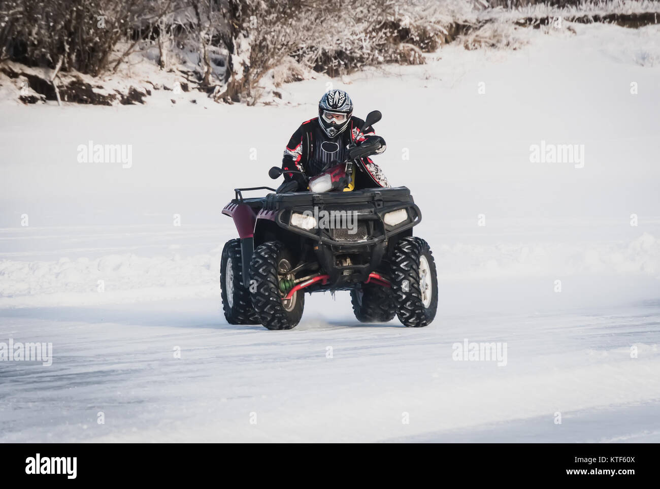 extreme Moto rider in gear on the ATV in the winter in the snow. The ...