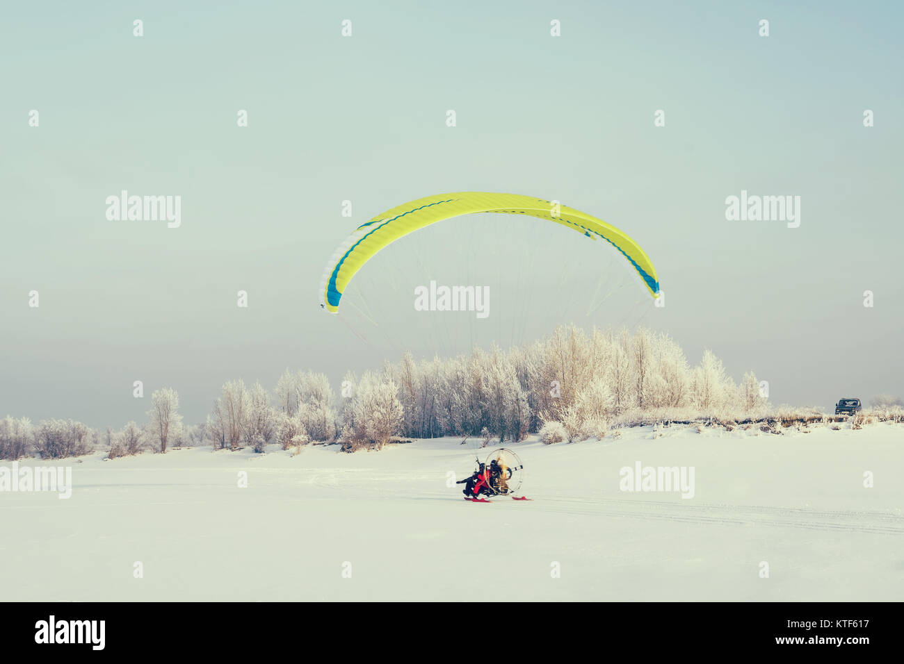 Adventure man active extreme sports pilot flying with paramotor paraglider paraglider motor. Moto paraglider prepares for takeoff with a snow surface Stock Photo