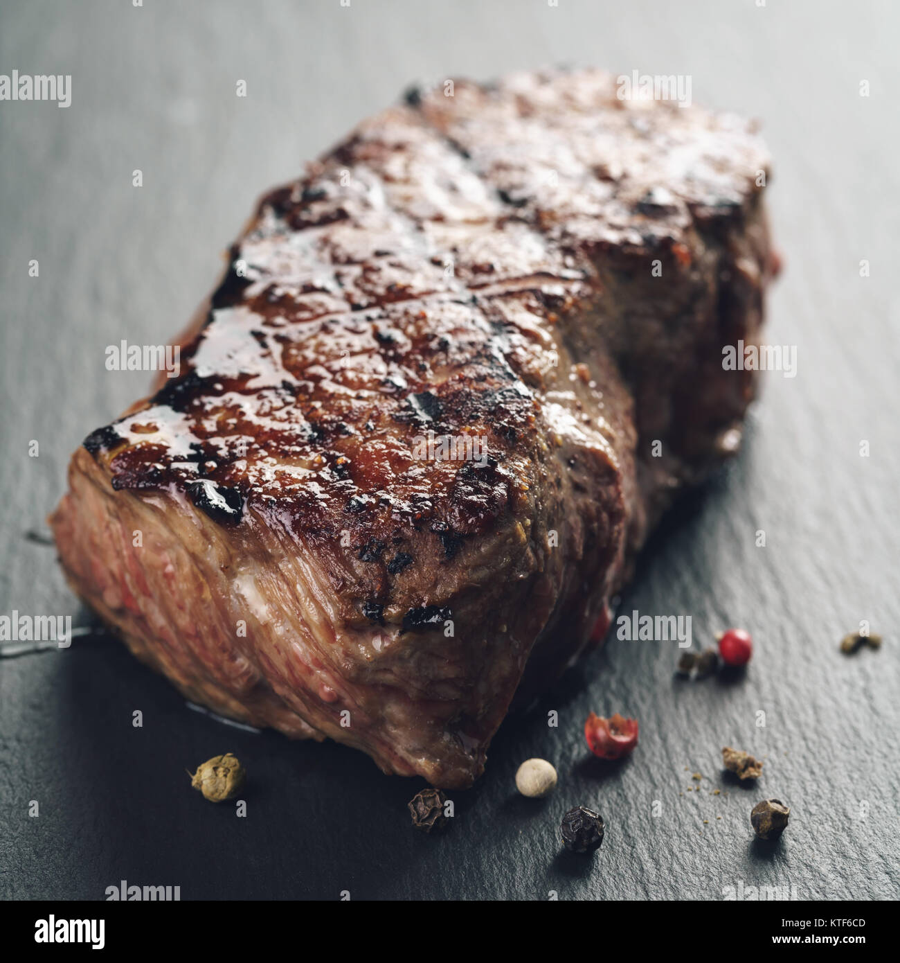 prepared beef steack with pepper on slate board closeup Stock Photo