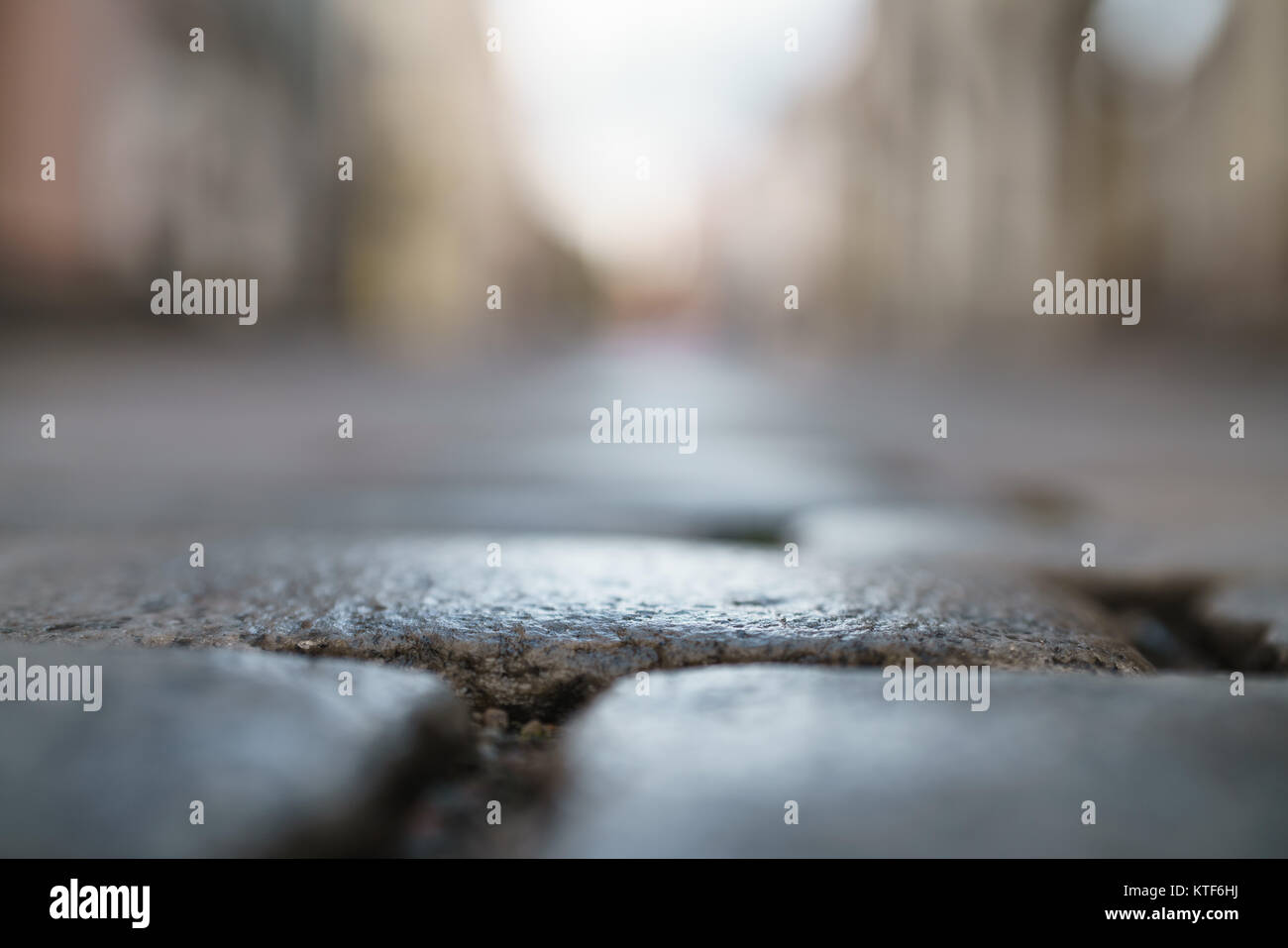 low angle closeup background of wet old pavement with blurred background Stock Photo