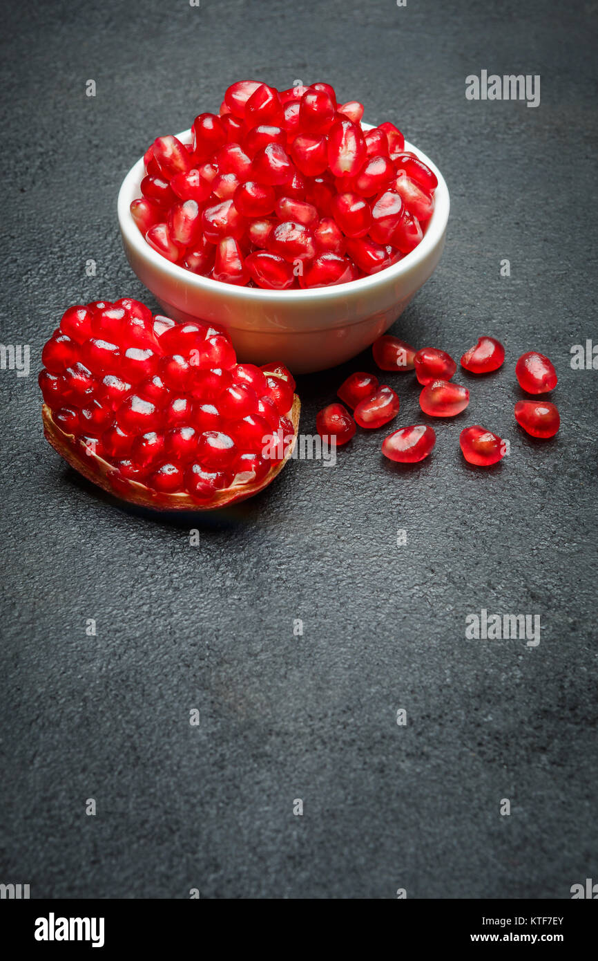 Pomegranate seeds close-up on dark concrete background Stock Photo