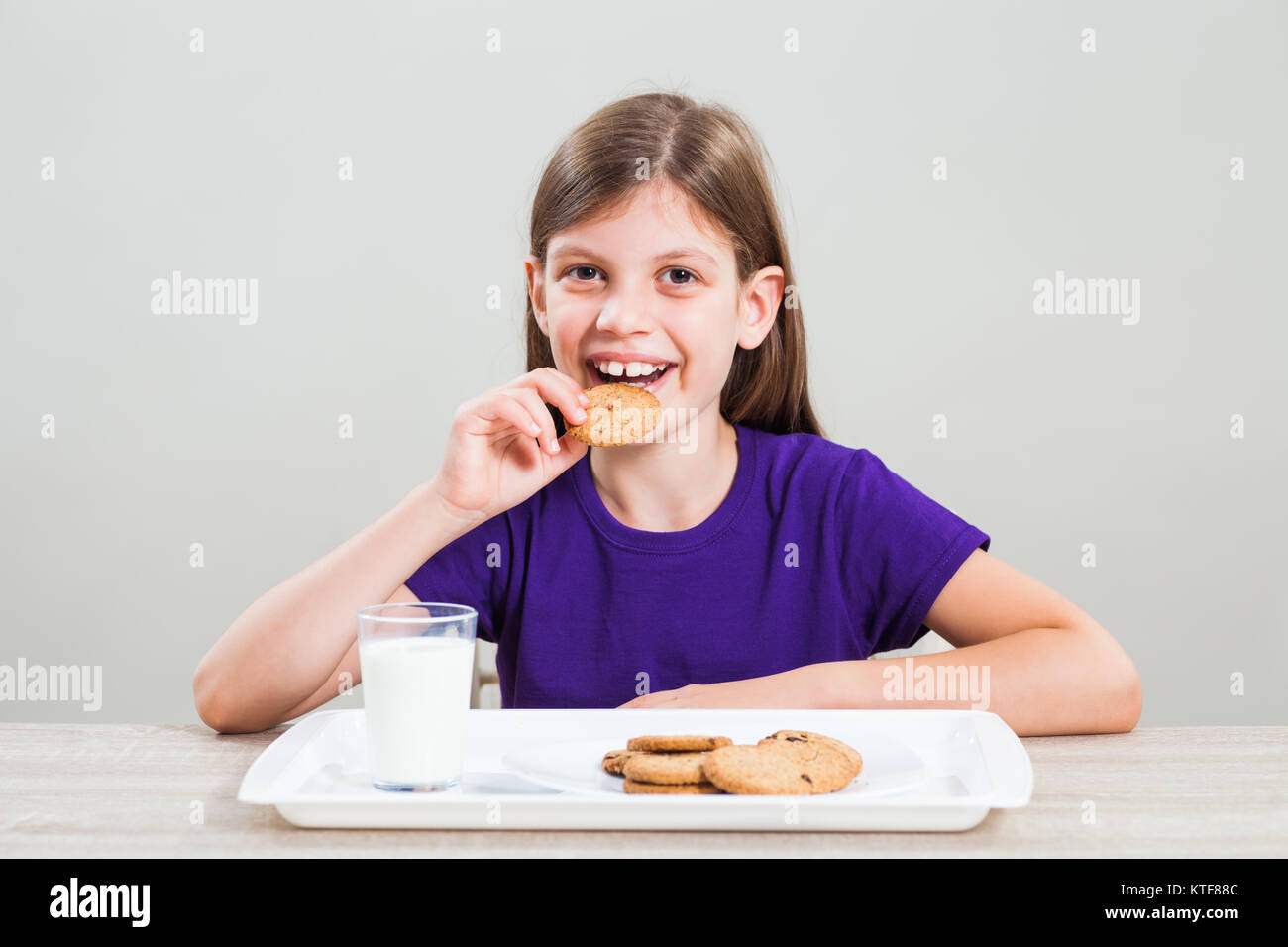Little girl is having cookies and milk for breakfast Stock Photo Alamy