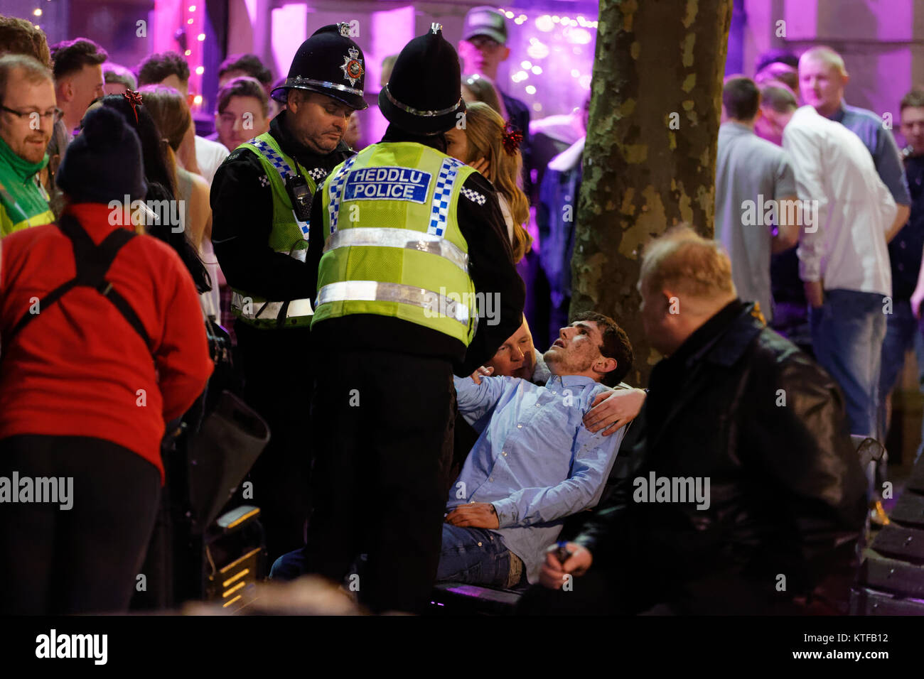Police officers speak with a young man in Wind Street, Swansea, Wales