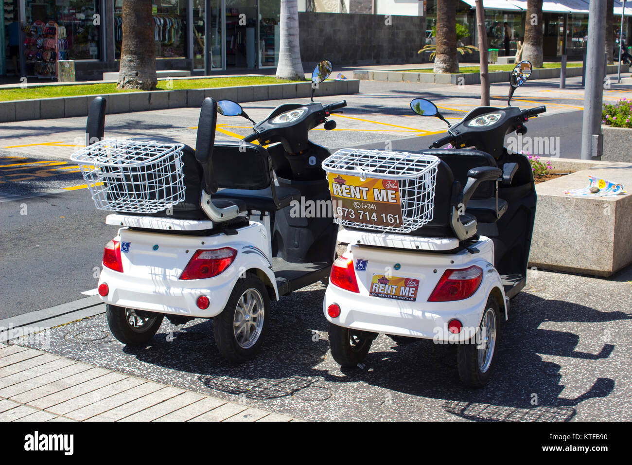 A pair of rented disability scooters known as scoot mobiles in Playa de las Americas in the Canary island resort of Playa de las Americas in Teneriffe Stock Photo