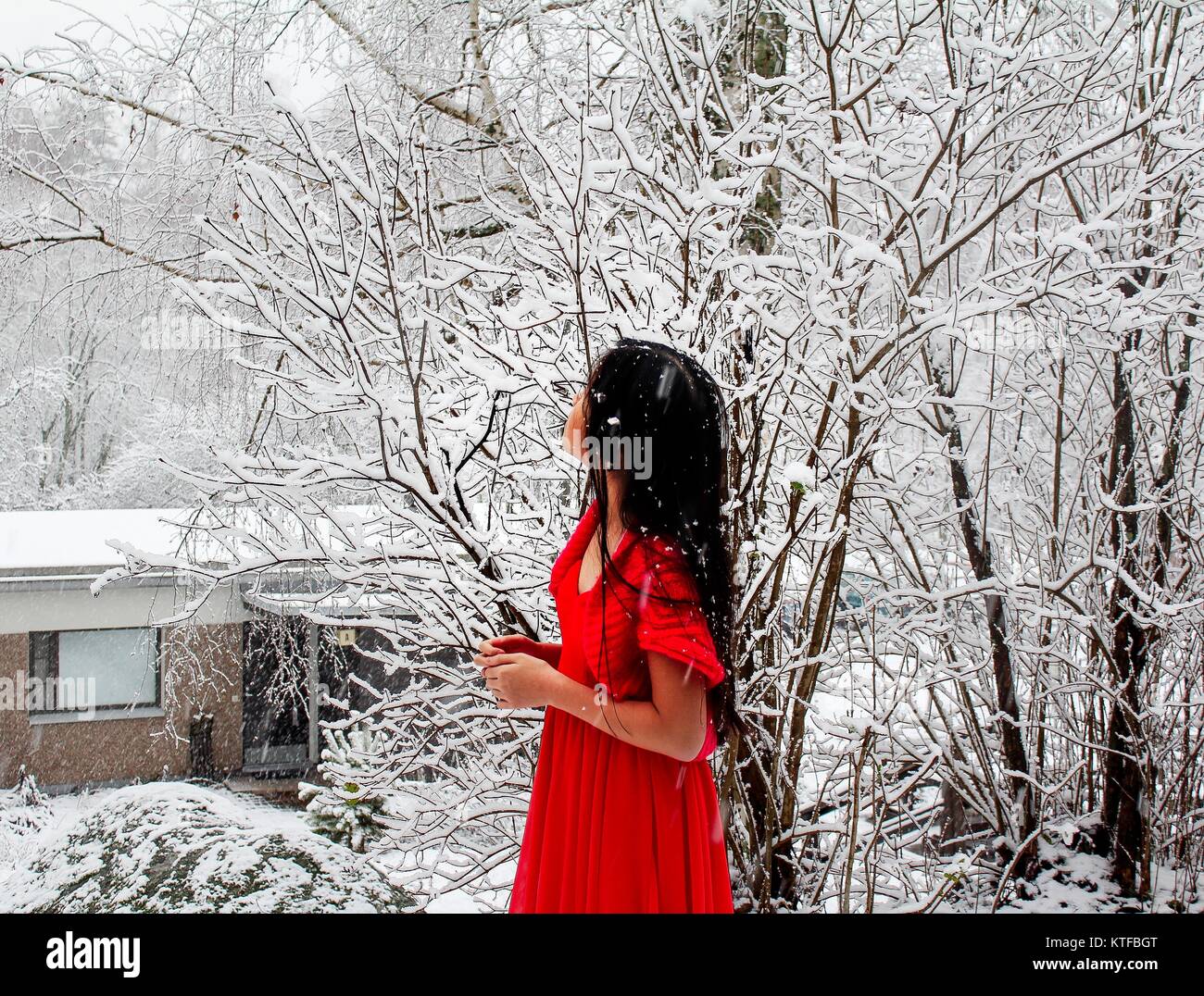 Red girl in snowing winter in Finland Stock Photo