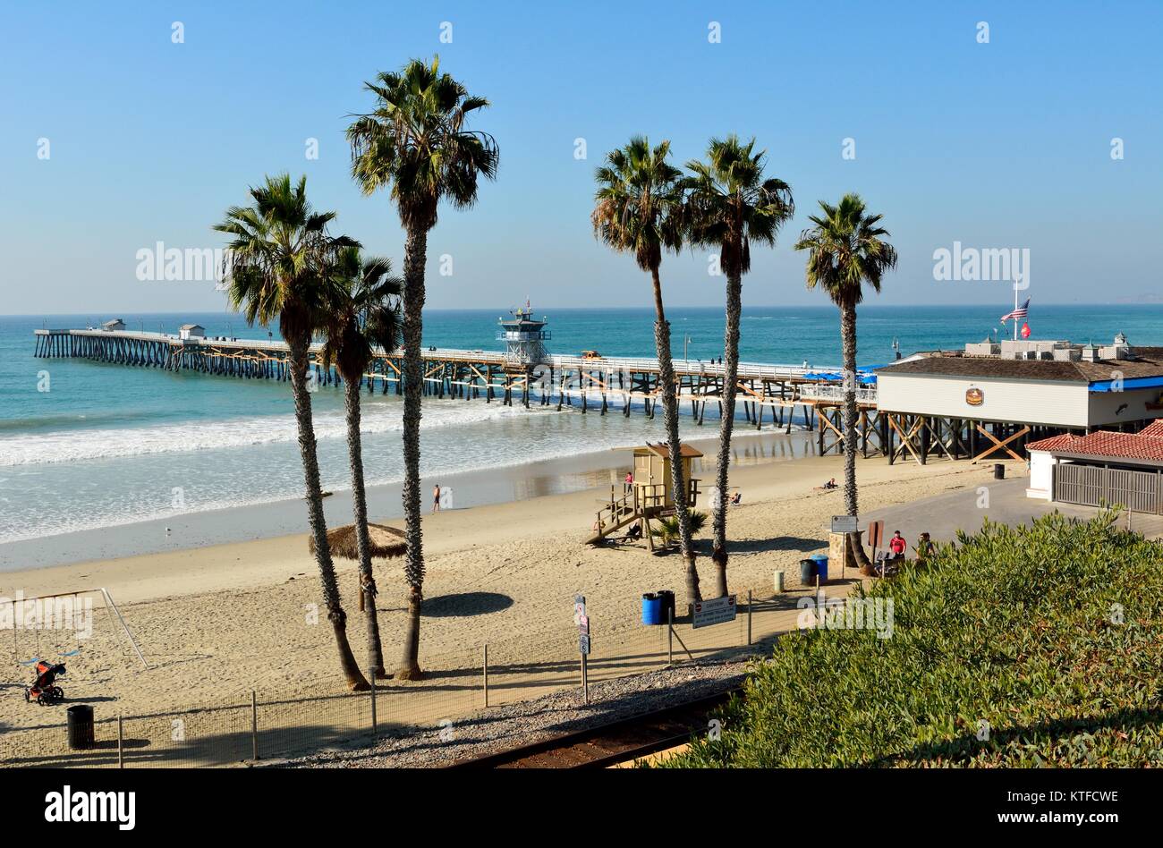 San Clemente, California, United States of America - December 1, 2017. View of San Clemente pier and T-Street beach, with palm trees, people and comme Stock Photo