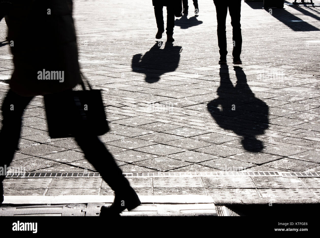 People silhouettes and shadows on city streets in black and white Stock Photo