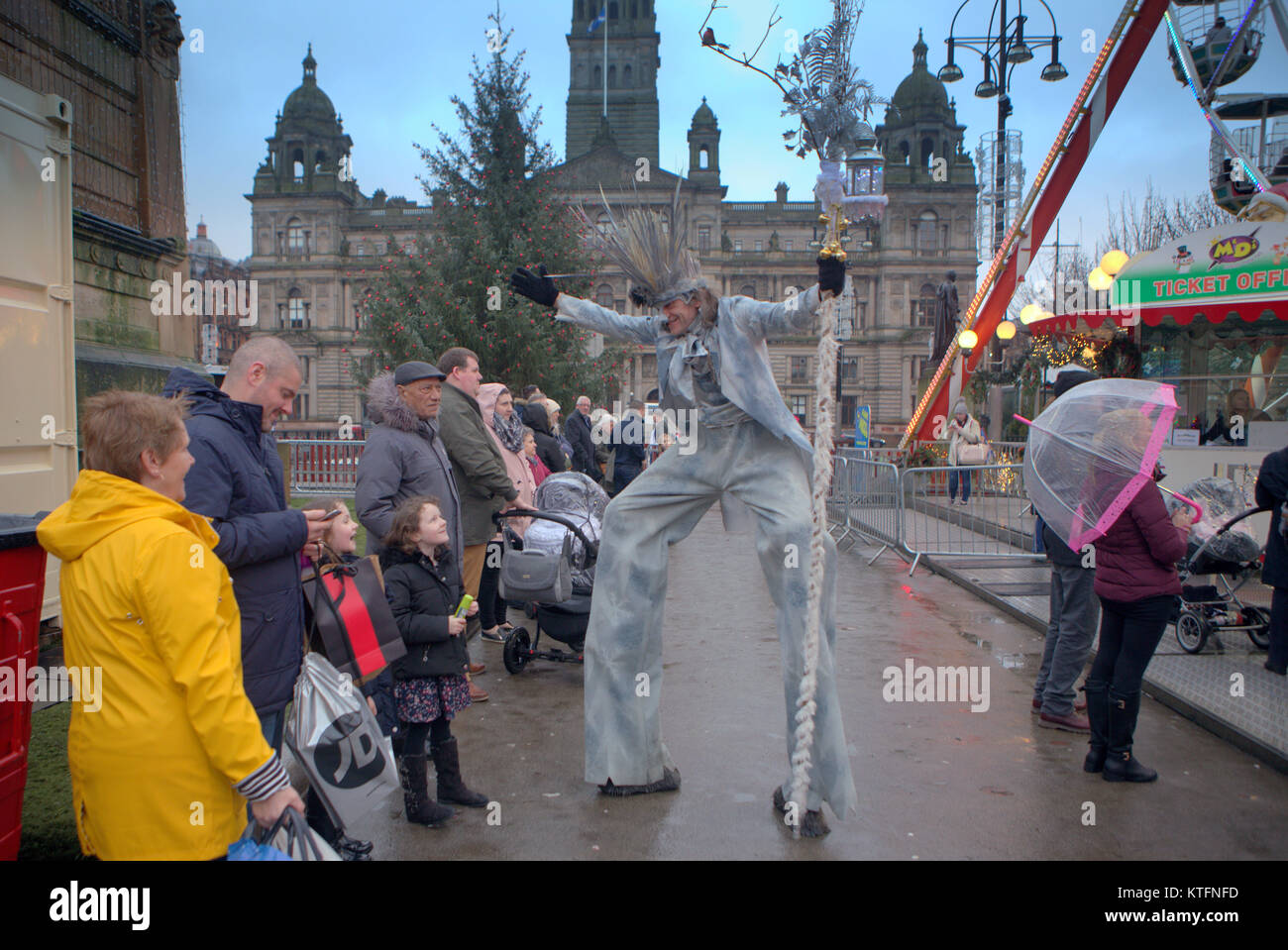 Weather: Rain and wind greet the last minute Christmas Eve visitors to the Christmas fayre meet stilt walker  jack frost  in the city’s George square. Stock Photo