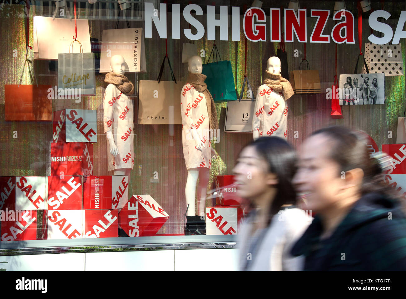 Tokyo, Japan. 26th Dec, 2017. Pedestrians pass before an aparel shop in Tokyo on Tuesday, December 26, 2017. Japan's consumer price index rose 0.9 percent in November, increasing 11th consecutive month, the government announced on December 26. Credit: Yoshio Tsunoda/AFLO/Alamy Live News Stock Photo