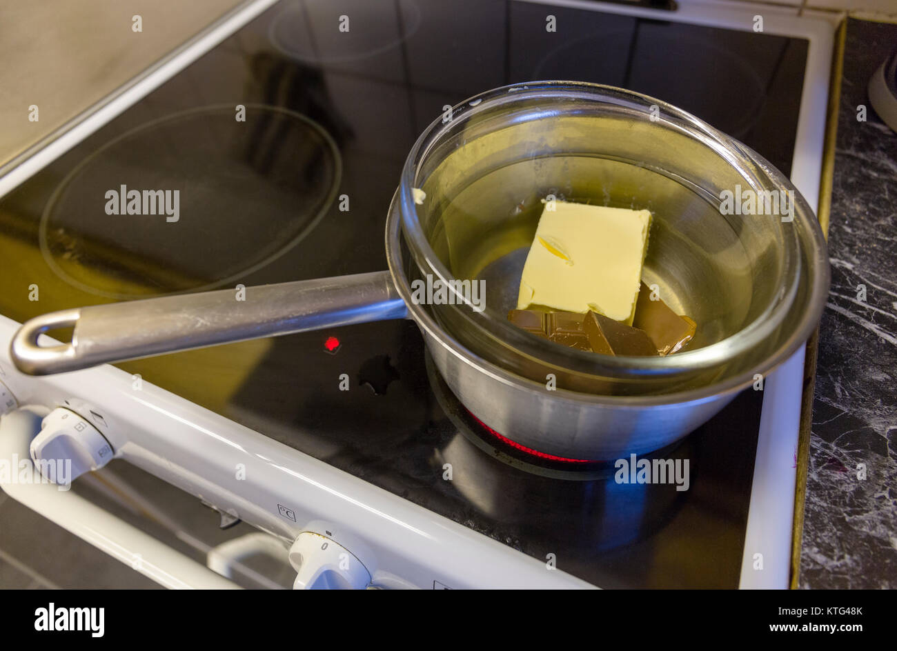 Chocolate and butter melting in hot water bath on stove during baking