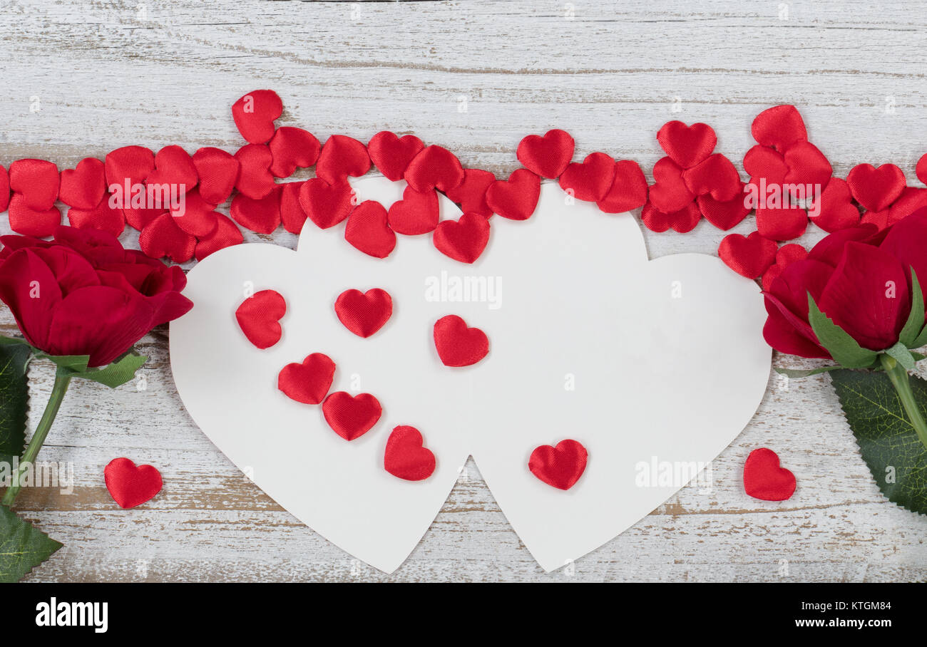 Valentines card with red heart shapes and roses on rustic white wood in ...