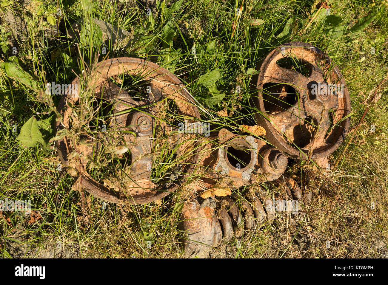 rusty engine parts lying in weeds in the remote mountain village of Shenako in the Tusheti region of Georgia Stock Photo
