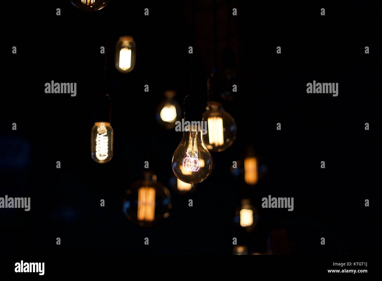 Interior depth of field vintage electric light bulbs in the foreground in dimly lit Western New York brew pub in East Aurora, New in York Erie County Stock Photo