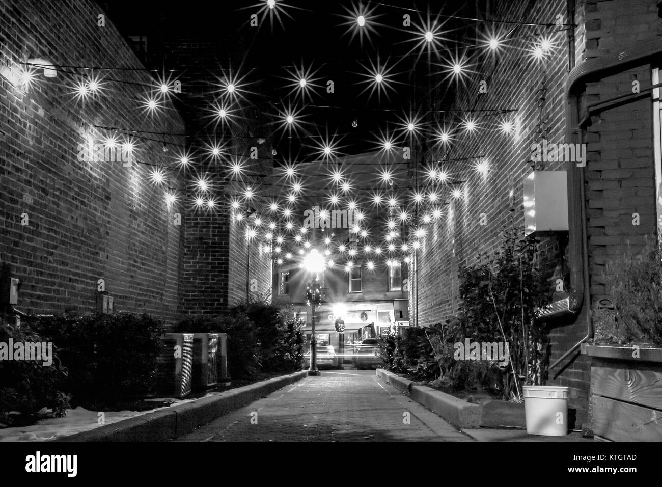 Exterior black and white long exposure stock photo of lights hanging over alley in front of coffee shop in Cranford, New Jersey in Union County Stock Photo