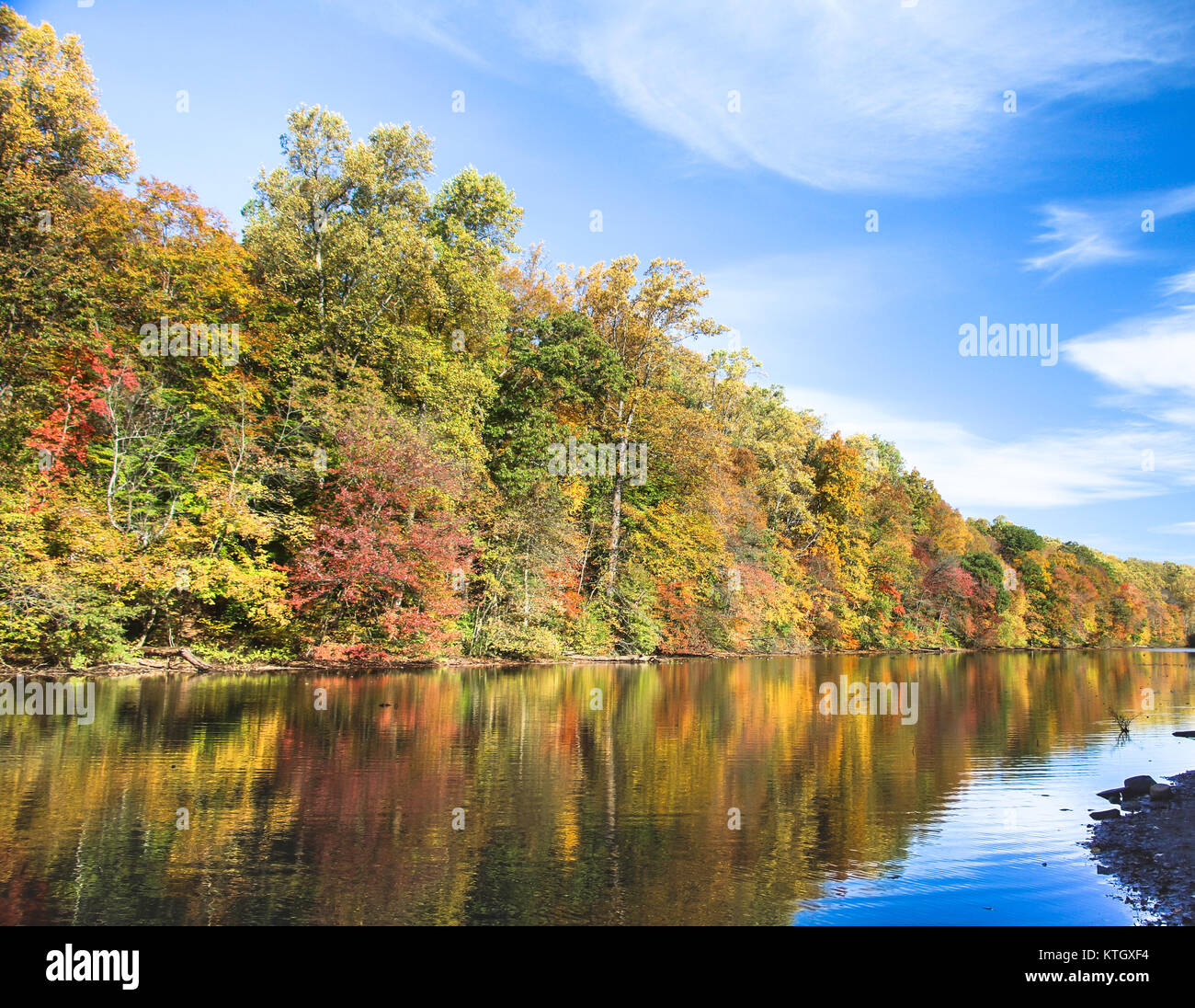 Trees on shore of Lake Surprise with colorful leaves mirroring off of the water on the Watchung Reservation in Mountainside, New Jersey Stock Photo