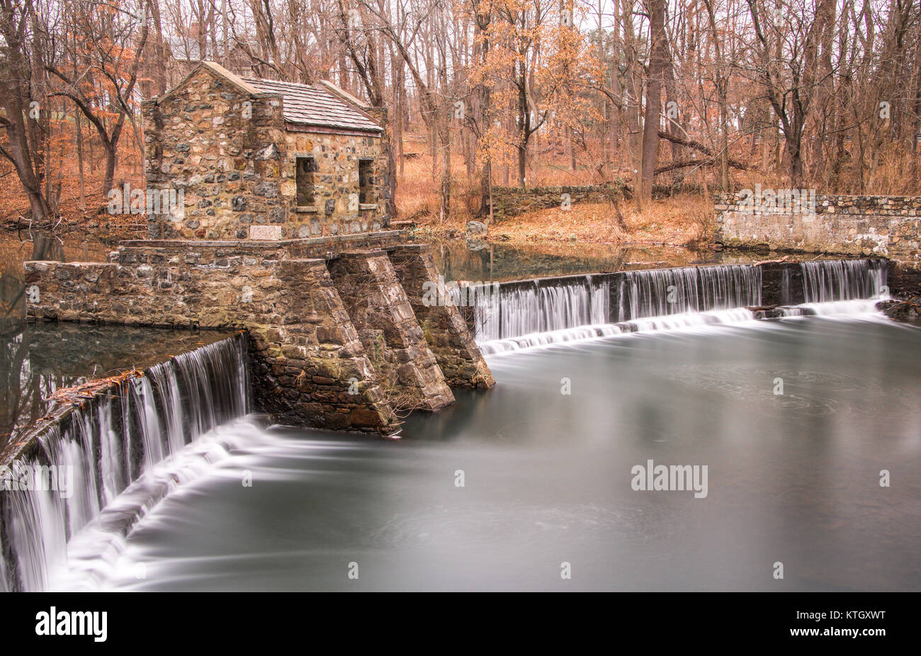 Exterior daytime long exposure stock photo of stone structure on dam and waterfall on Speedwell Lake in Morristown, New Jersey in Morris County Stock Photo