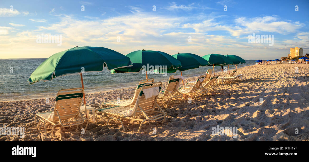 Umbrellas along Vanderbilt Beach in Naples, Florida, USA at sunset Stock Photo