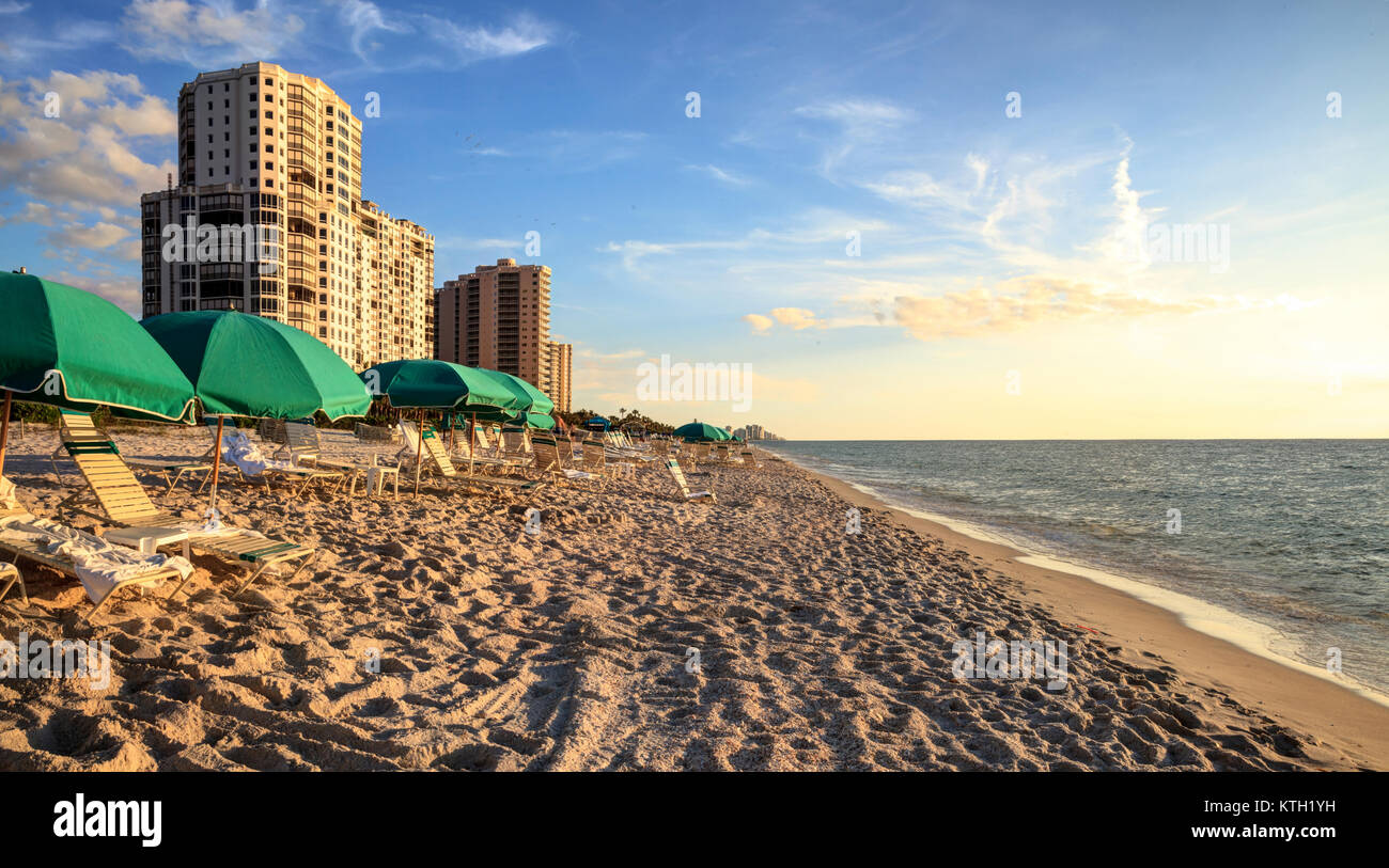 Umbrellas along Vanderbilt Beach in Naples, Florida, USA at sunset Stock Photo