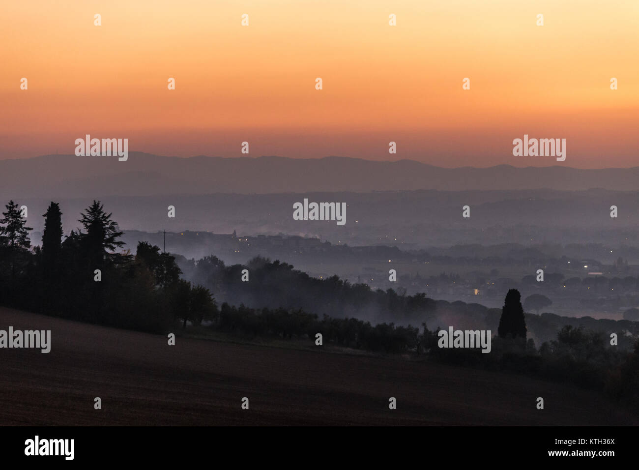 Mist at sunset filling the valley beneath Brufa town (Umbria) Stock Photo