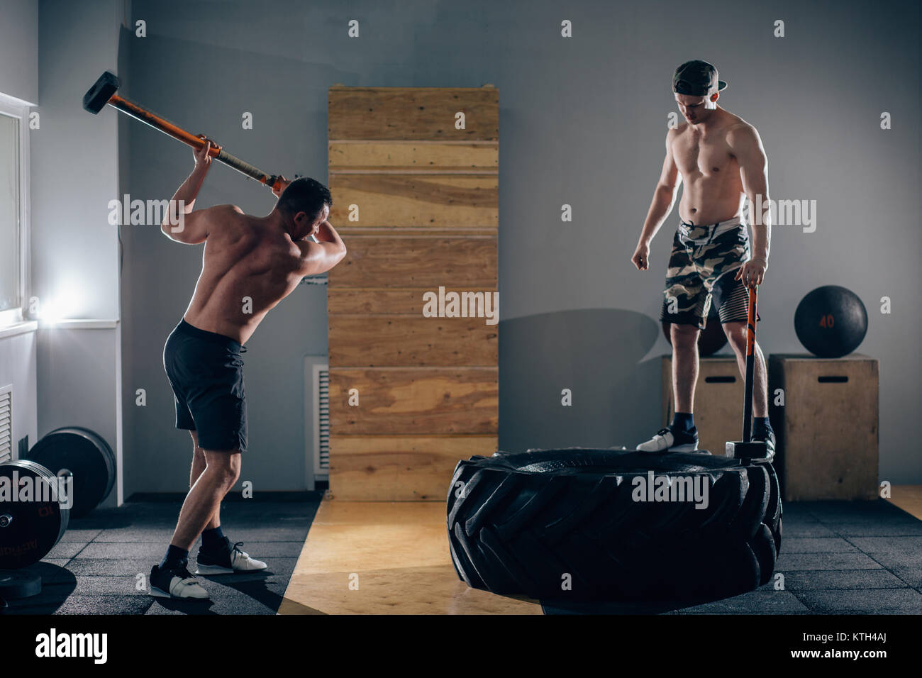 Sledgehammer Tire Hits men workout at gym with hammer and tractor tire