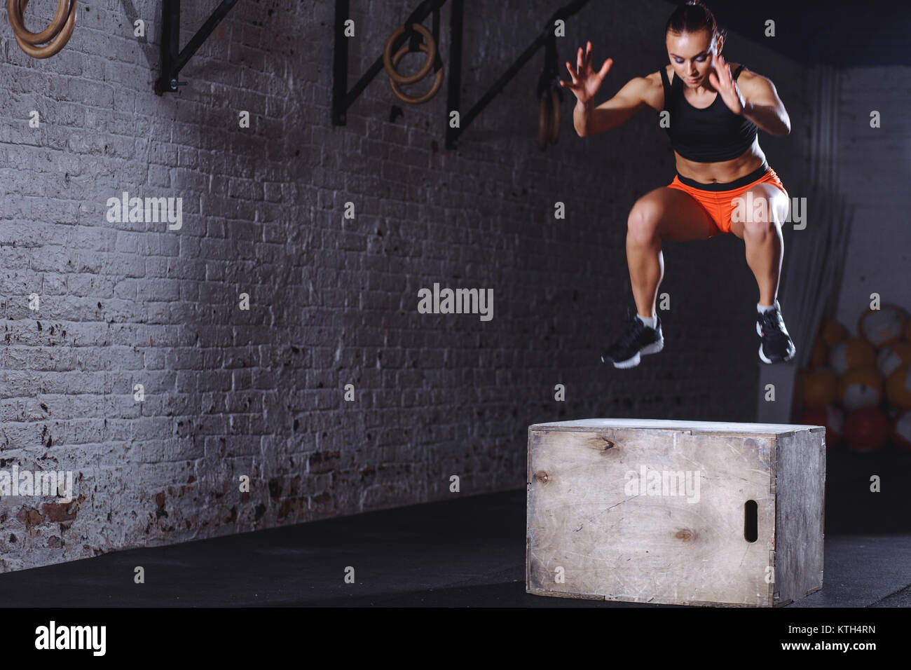 fit woman doing box jump exercise. Muscular woman doing box jumps at