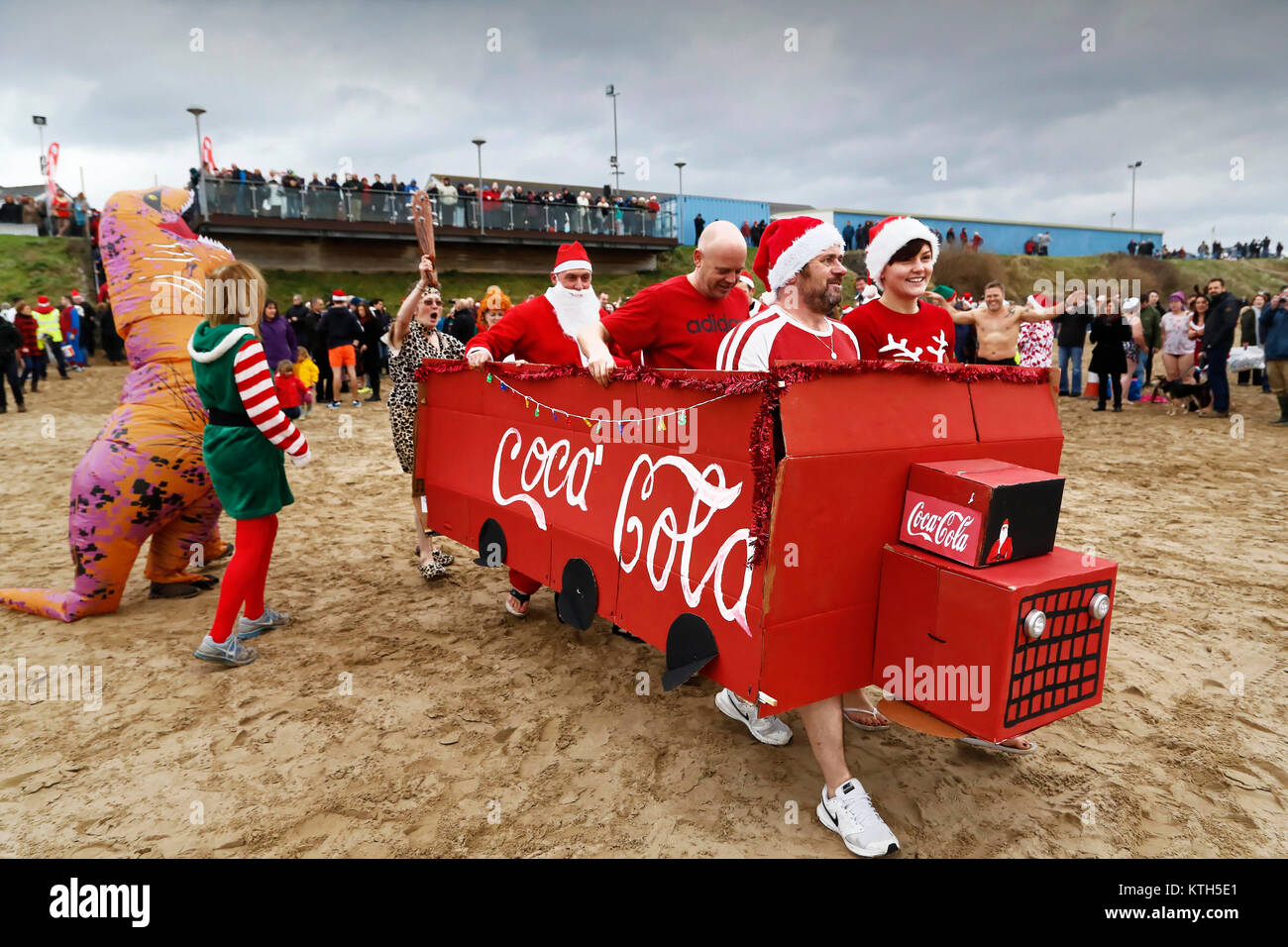 People in Santa fancy dress and a make-shift Coca Cola truck Stock Photo