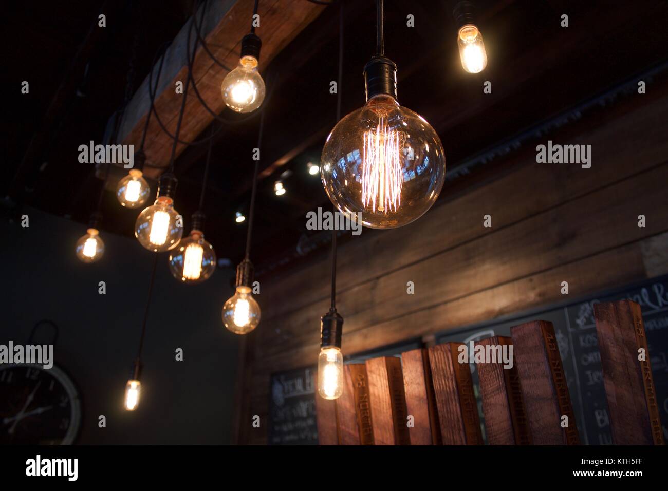 Interior depth of field vintage electric light bulbs in the foreground in dimly lit Western New York brew pub in East Aurora, New in York Erie County Stock Photo
