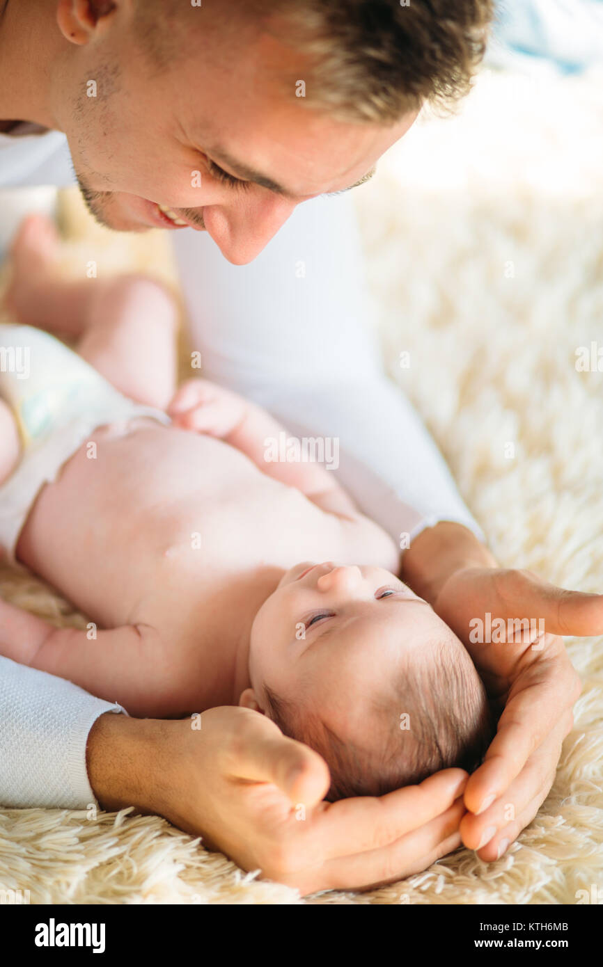 Father lying on bed and holds his baby Stock Photo - Alamy