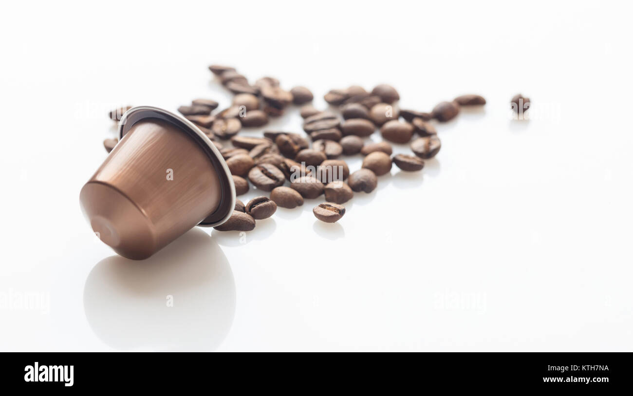 Espresso coffee capsule and coffee beans on white background, Closeup