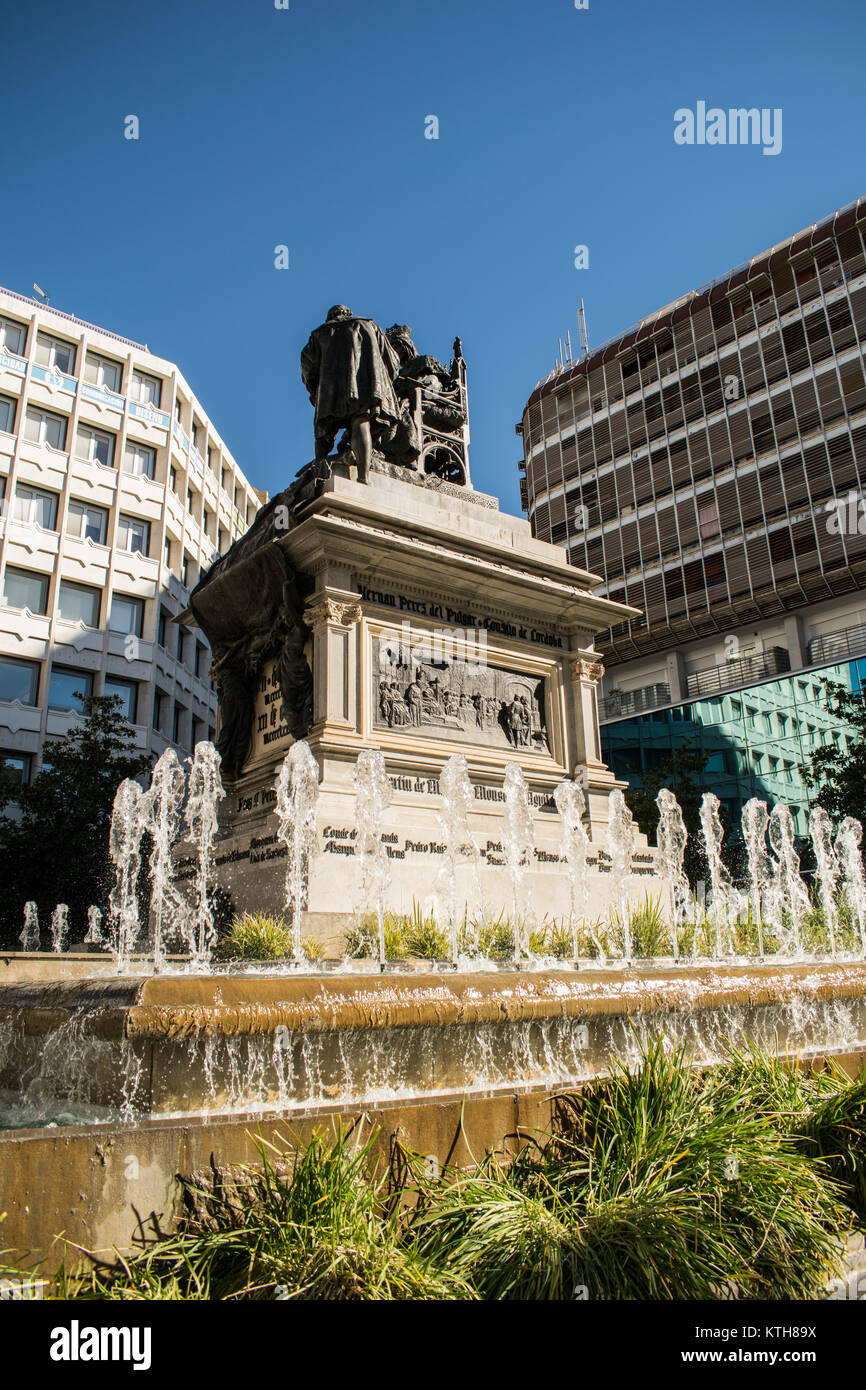 A statue in a plaza in Granada, Spain surrounded by fountains Stock
