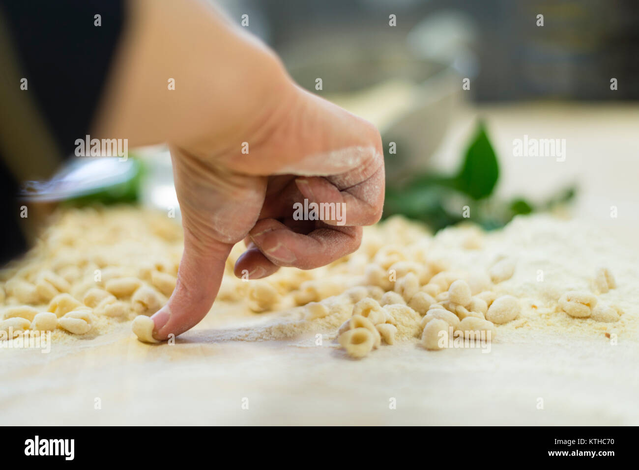 Woman making and preparing pisarei gnocchi typical pasta from Emilia Romagna, Piacenza, Italy at the restaurant kitchen preparation Stock Photo