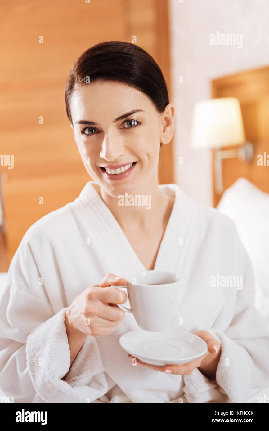 Enthusiastic glad woman enjoying coffee Stock Photo