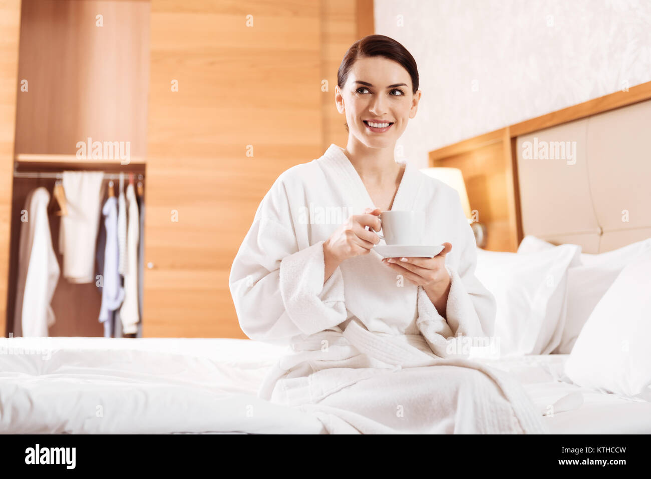 Cool relaxed woman sitting on the bed Stock Photo