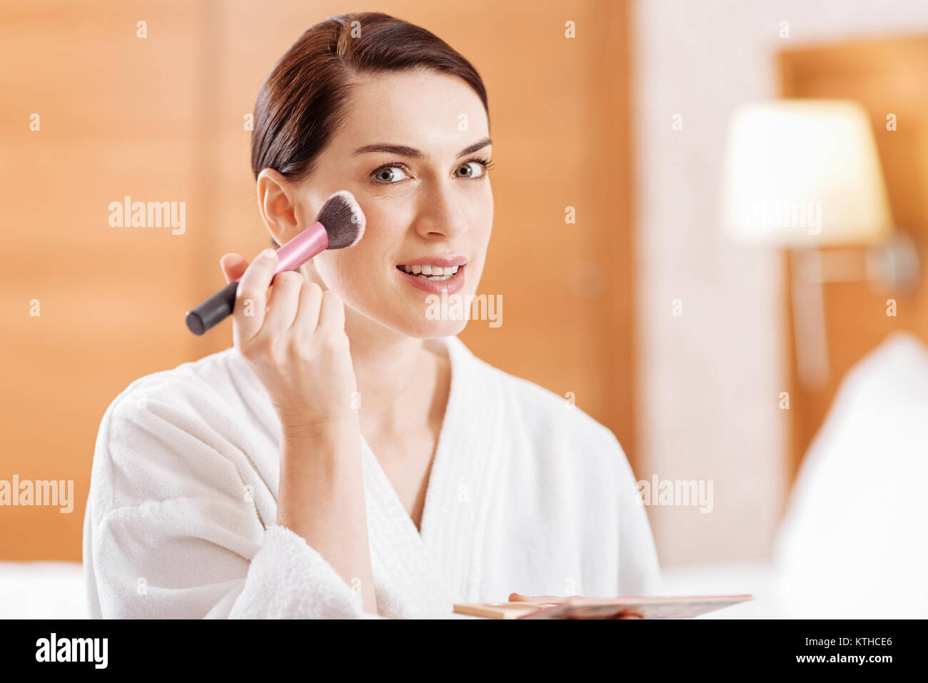 Brunette young woman applying powder Stock Photo