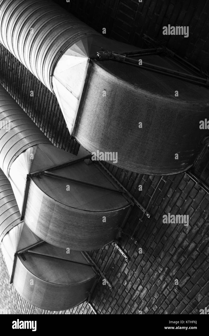 Outdoor ventilation tubes mounted on brick wall, black and white photo Stock Photo