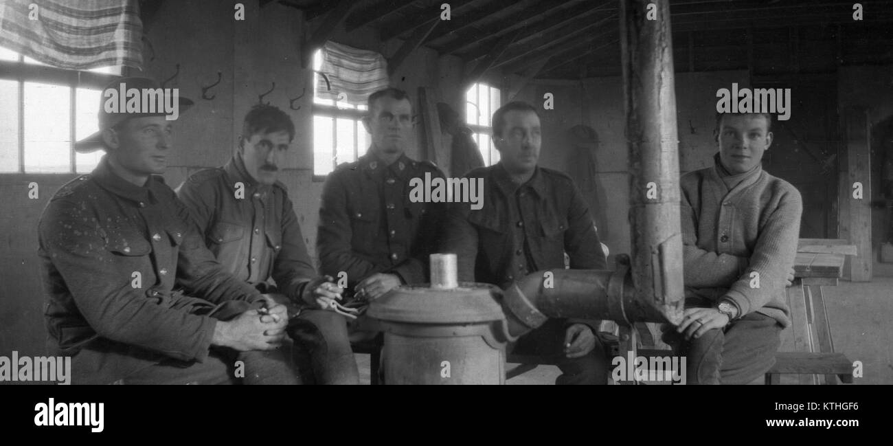 group of men sitting around stove in barracks, place unknown, probably from the First World War era. Stock Photo